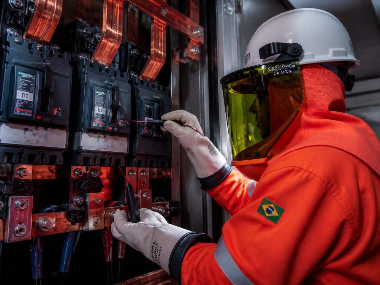 Eletricista com EPI classe 2 em painel elétrico de média tensão